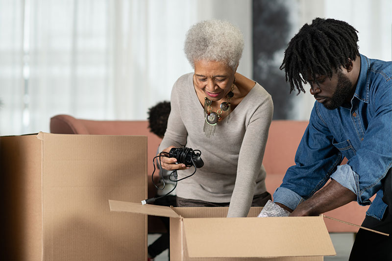 A man goes through boxes with his aging mother, a big part of downsizing your parents’ home.