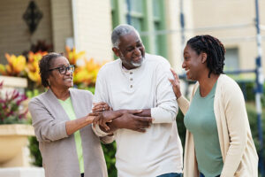 A woman caring for aging parents shares a happy moment with her mom and dad.