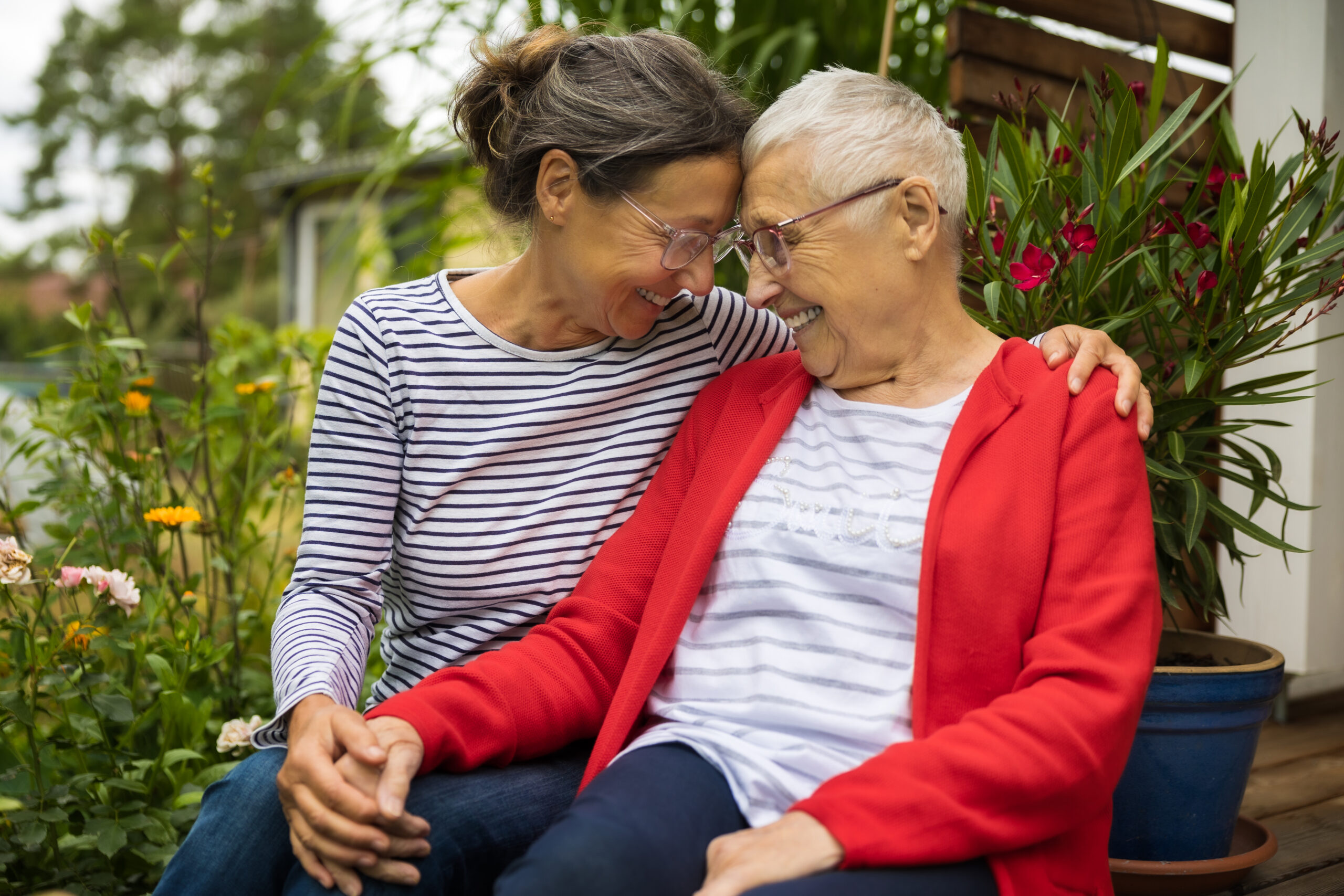 A woman tries nonverbal strategies for Alzheimer’s care, like smiling and gently holding her mother’s hand.