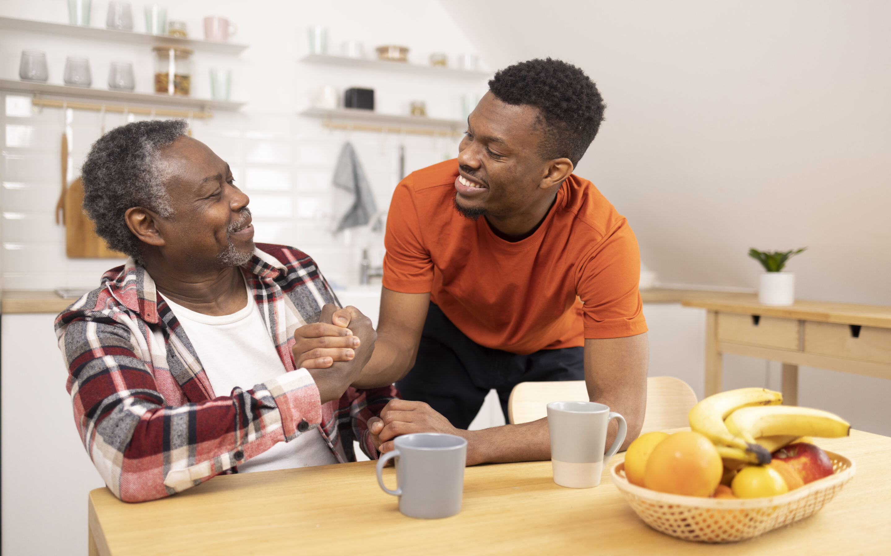 A man shakes hands with his father as he helps him navigate life with chronic illness.