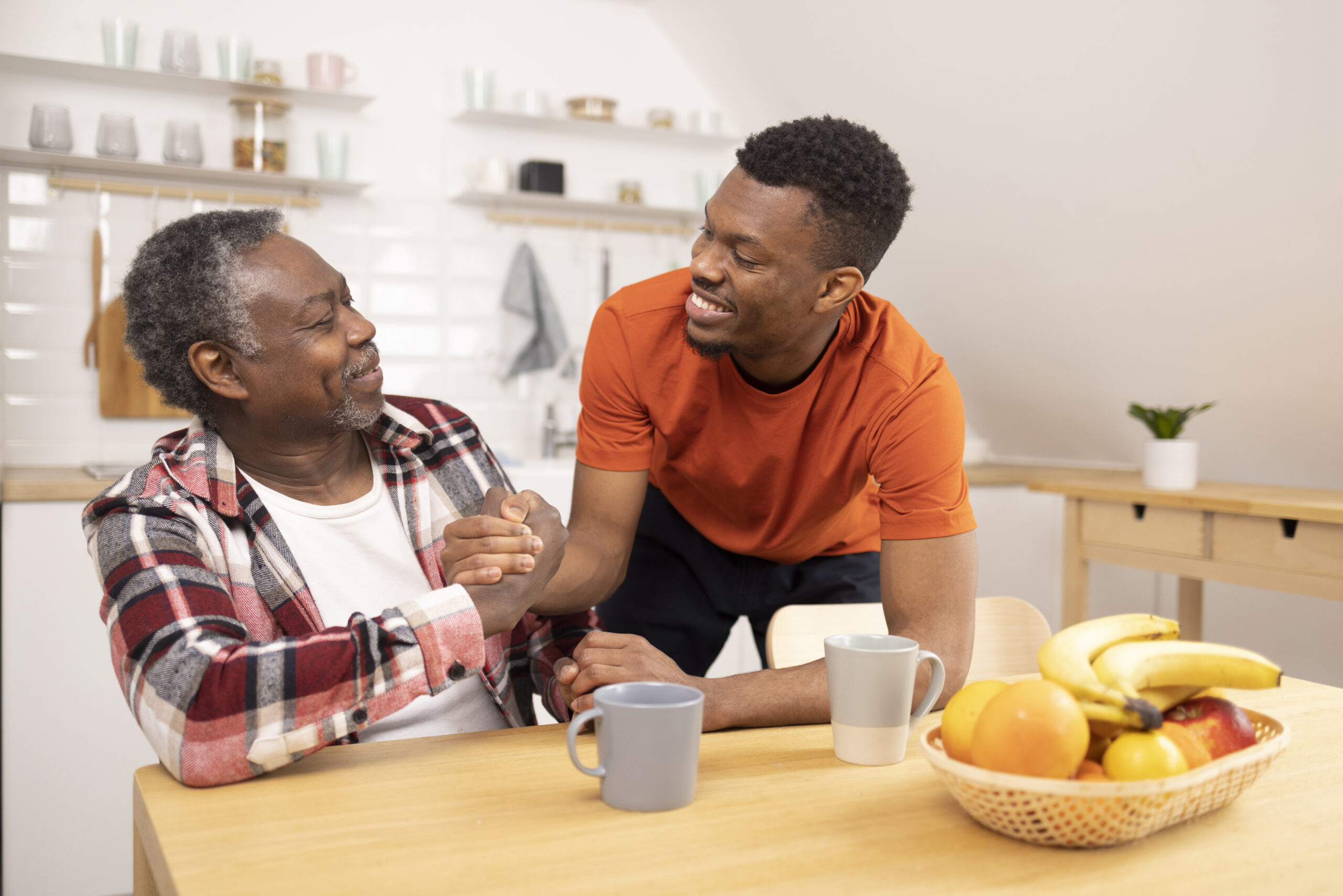 A man shakes hands with his father as he helps him navigate life with chronic illness.