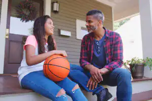 A parent comforts a child who is struggling with the emotional impact of dementia in a grandparent.