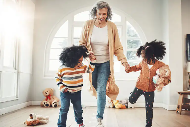 A woman who knows the importance of senior mobility support practices balancing exercises with her grandkids.